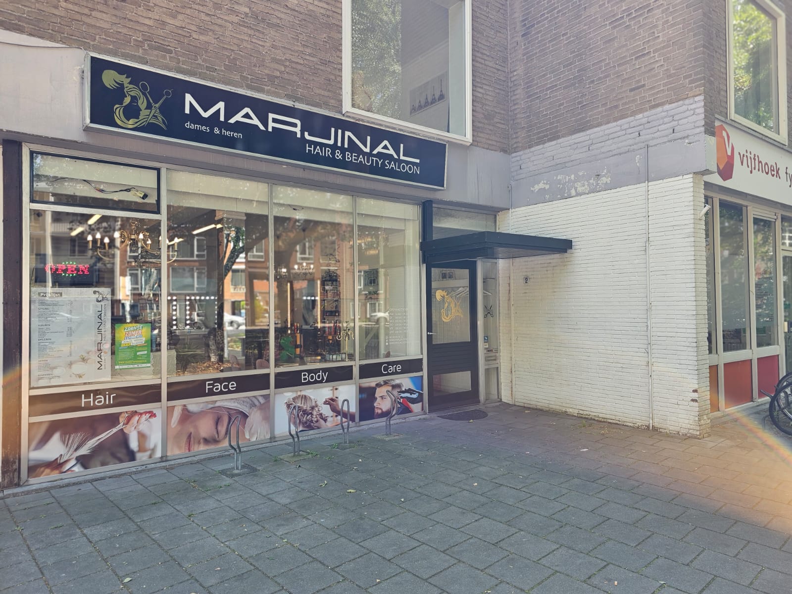 De gevel van Marjinal Salon aan de Coniferenstraat in Zaandam, met het navy uithangbord