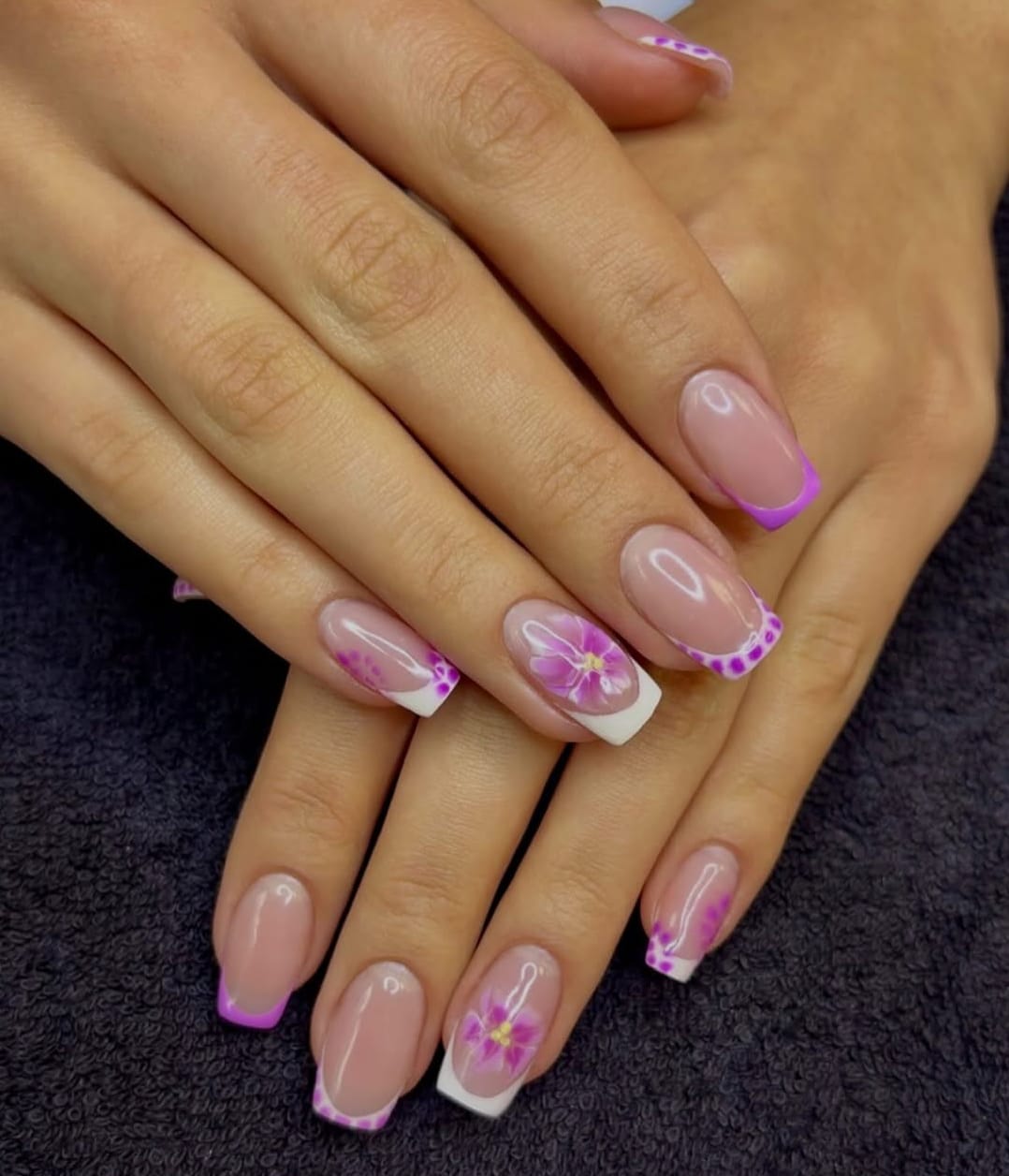 Nagels met roze French tip en paarse bloemetjes, gezet bij Marjinal Salon